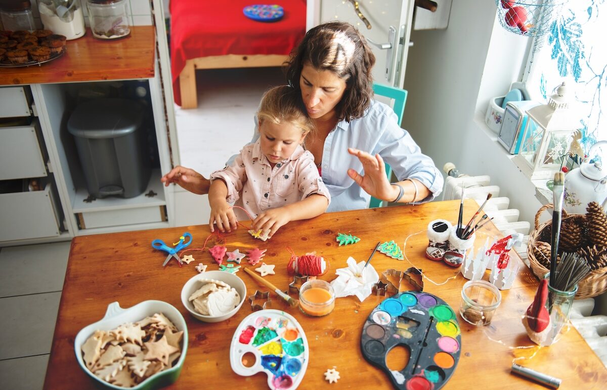 Mother and daughter decorating cookies together in a kitchen during the Festive Season.